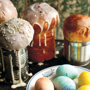Four loaves of Ukrainian Easter bread, paska, with a bowl of colored eggs in front of them